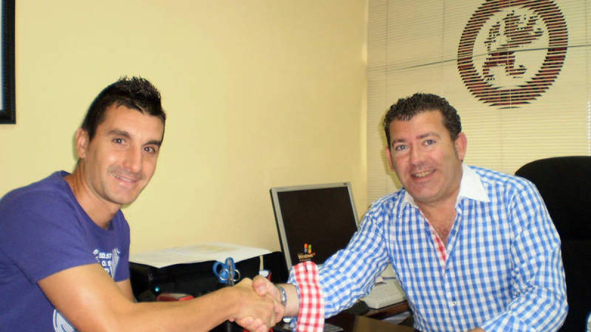 Alberto Negral estrecha la mano de Javier Baena tras firmar el contrato.