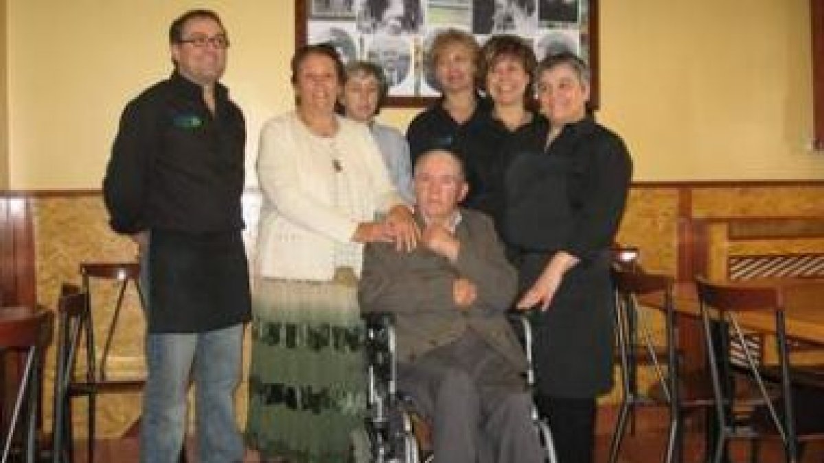 Los responsables del local con sus padres y empleados, bajo las fotos de los fundadores.