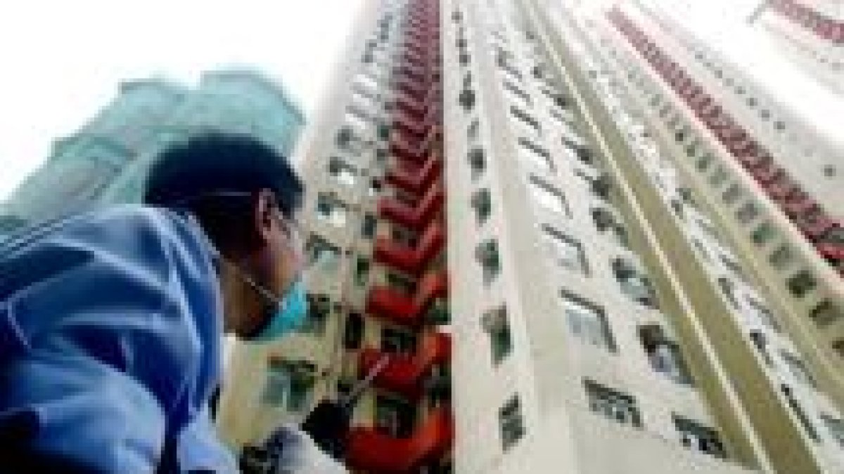Un policía custodia desde ayer la entrada del edificio de apartamentos Amoy Gardens