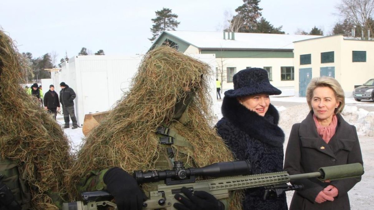 La ministra alemana de Defensa, Ursula von der Leyen (a la derecha), y la presidenta de Lituania, Dalia Grybauskaite, junto a un soldado en la ceremonia de bienvenida a las tropas de la OTAN.