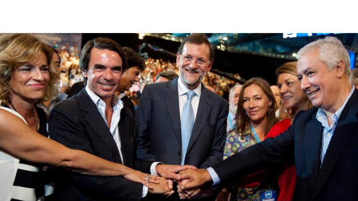 Ana Botella, Aznar, Rajoy, su esposa Elvira, Cospedal y Arenas se estrechan las manos en la clausura de la convención de Málaga.