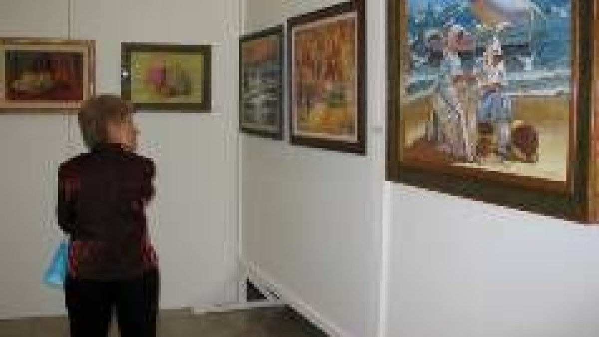 Una visitante de la exposición contempla algunas de las obras en la escuela de idiomas