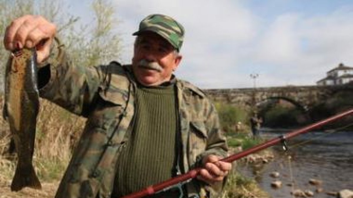 Un avezado pescador muestra una trucha sacada del Órbigo, el río con mayor concentración de cañas