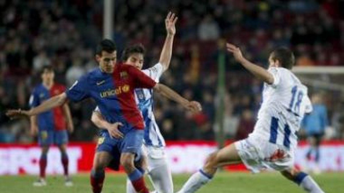 Sergio Busquets (i) pelea un balón con el delantero argentino Marco Rubén