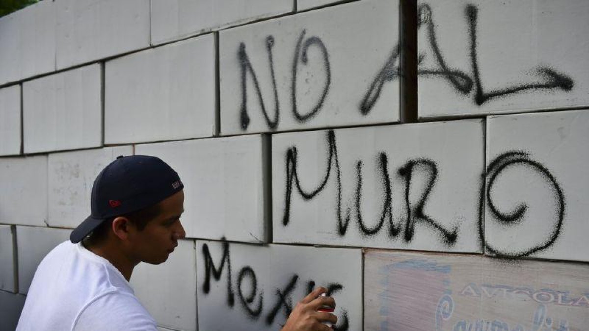 Pintadas sobre un muro hecho con cajas de cartón en contra del muro, en México .