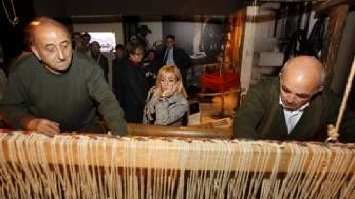 Dos expertos artesanos del pueblo maragato y tejedor de Val de San Lorenzo manejan el telar expuesto