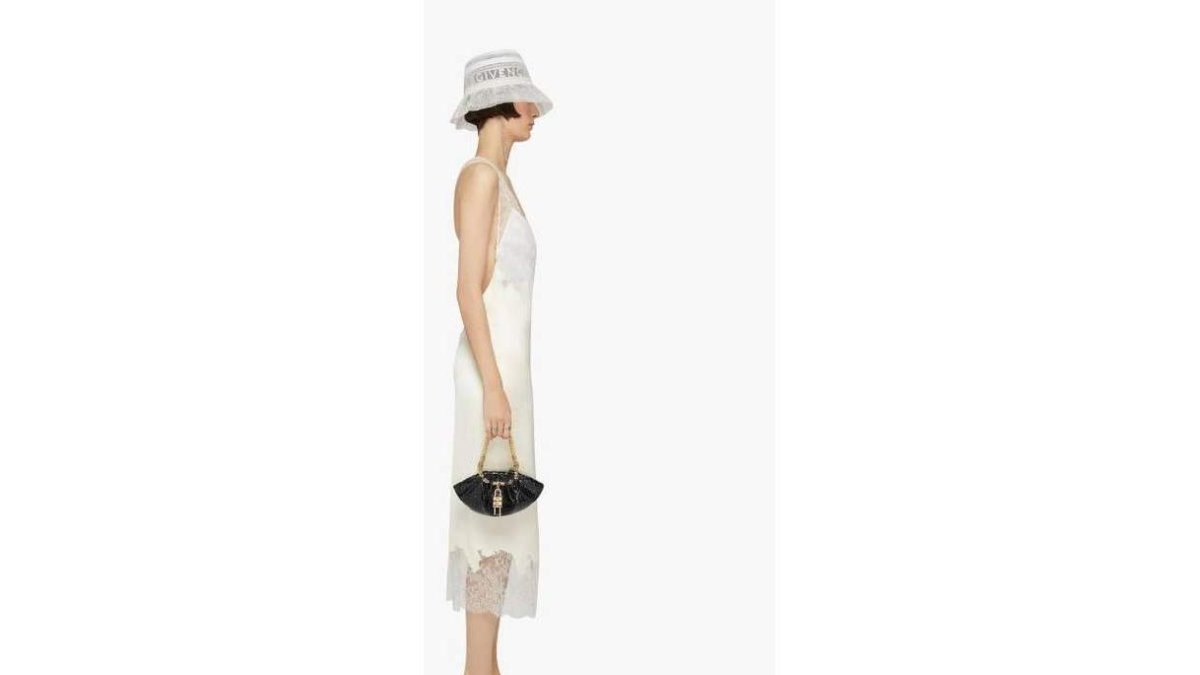 Dos de los modelos de la nueva colección de Givenchy. Botas de estilo militar de goma, gorras y riñoneras para él. Sombrero como si fuera un casco de encaje, vestido lencero y sandalias para ella.