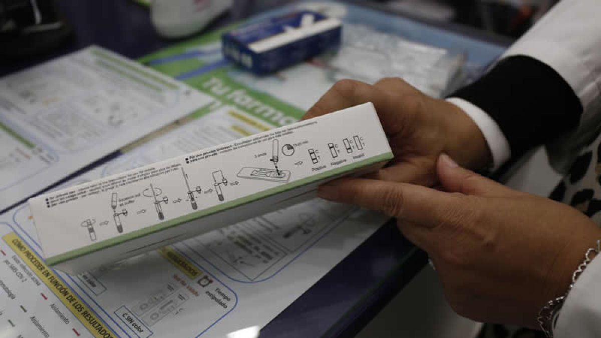 Una farmacéutica muestra las instrucciones para realizar un test de antígenos. FERNANDO OTERO PERANDONES