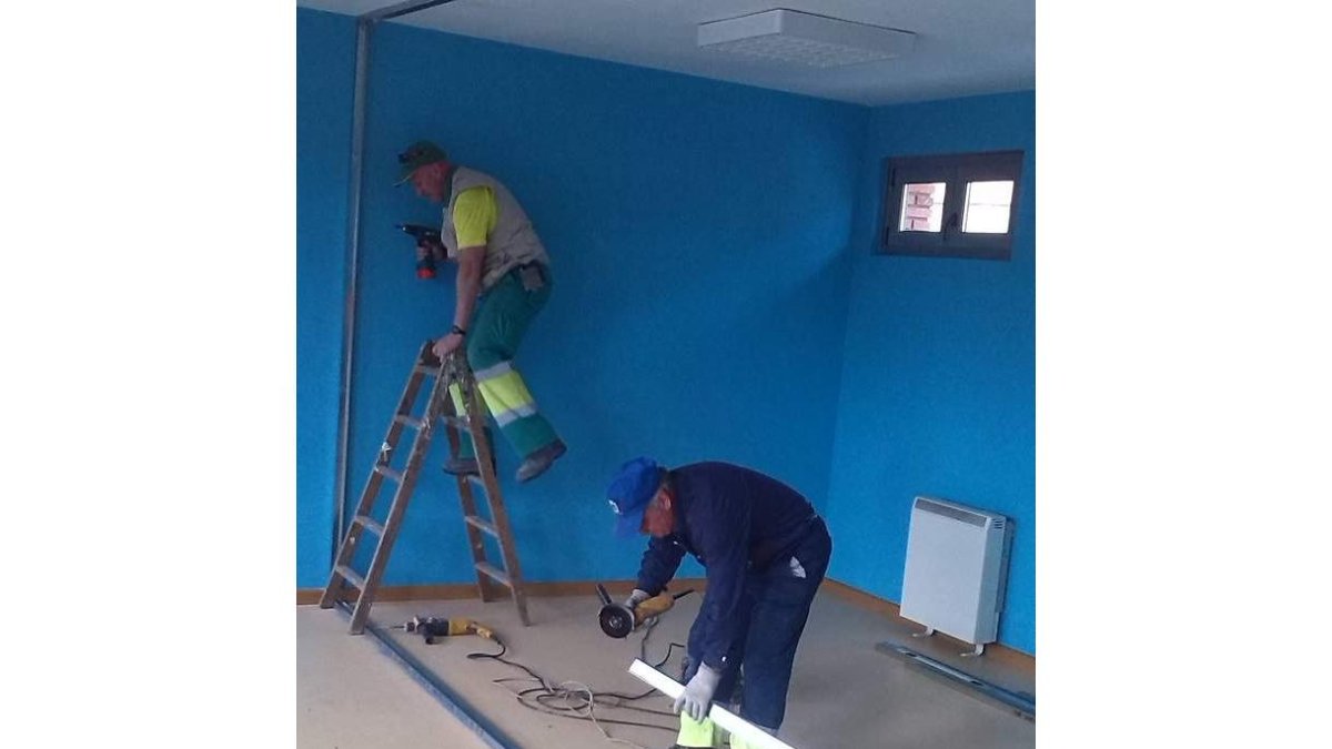 Dos operarios realizan obras de adaptación para el consultorio.