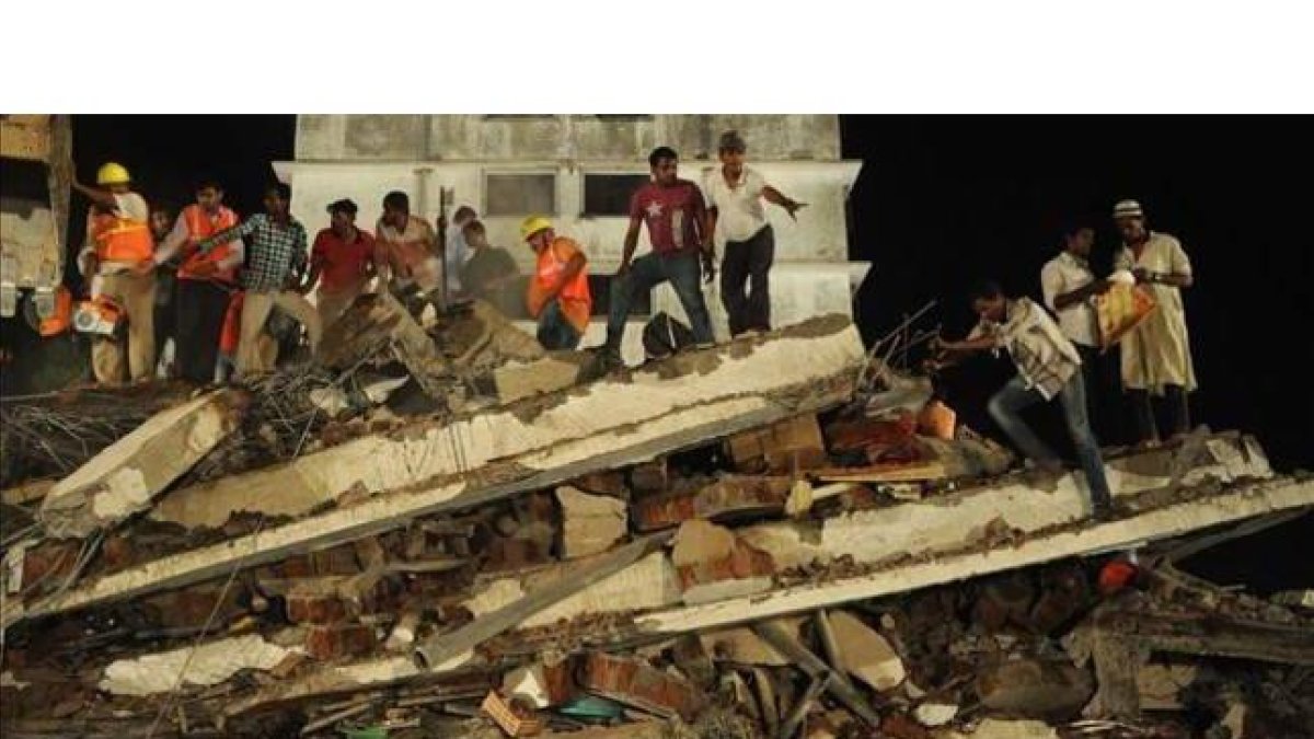 Personal de rescate y residentes del lugar buscan supervivientes bajo los escombros, el jueves por la noche en Thane.