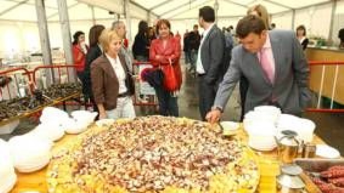 Crepo y López Riesco ante la gran tabla de pulpo de la feria del marisco