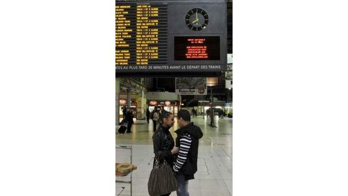 Una pareja espera su tren en una estación de París.