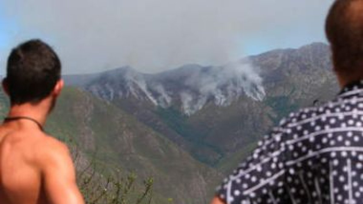 Dos vecinos de Santo Tirso de Cabarcos observan a lo lejos el nuevo rumbo del fuego de Barjas