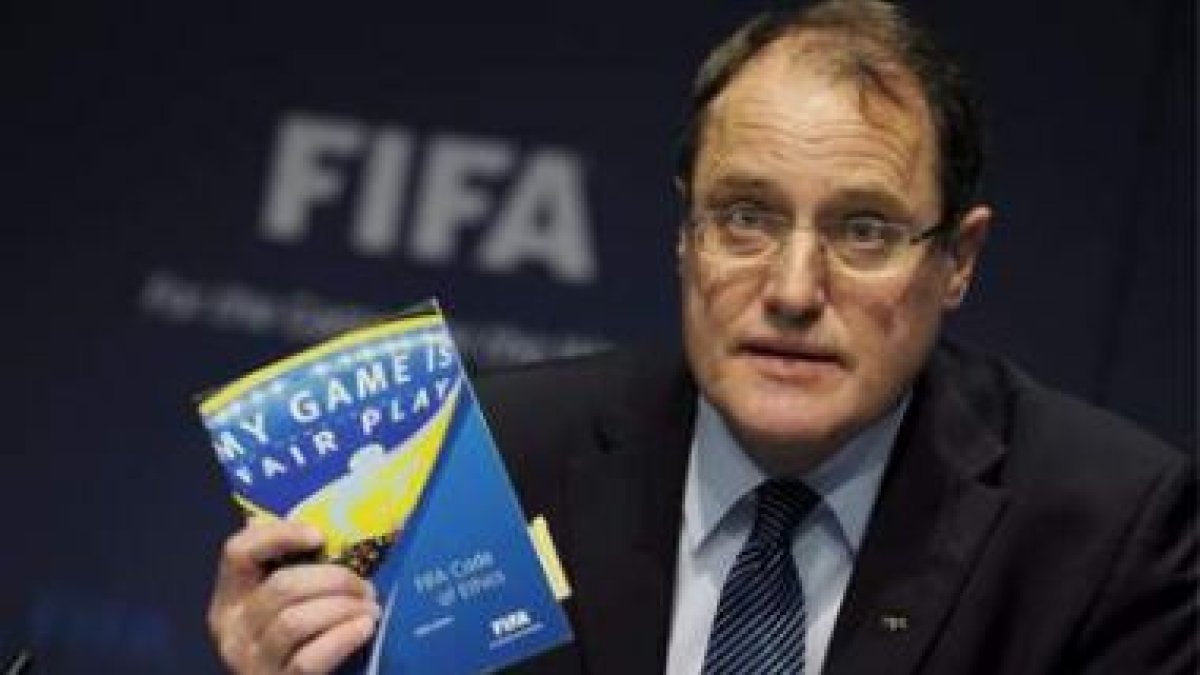 El presidente del Comité de Ética de la Fifa, Claudio Sulser, posa con un código de fair play, antes