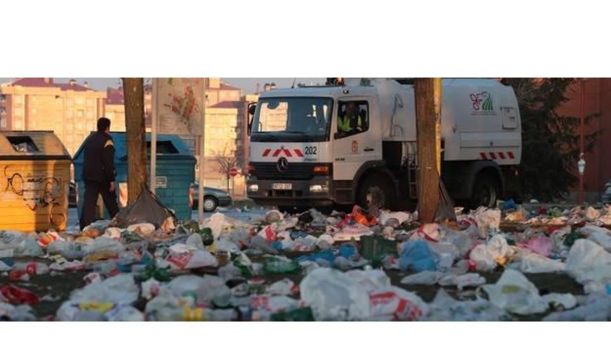 Los servicios de limpieza del Ayuntamiento recogen la basura dejada por los 5.000 jóvenes que participaron ayer en el botellón en el Campus