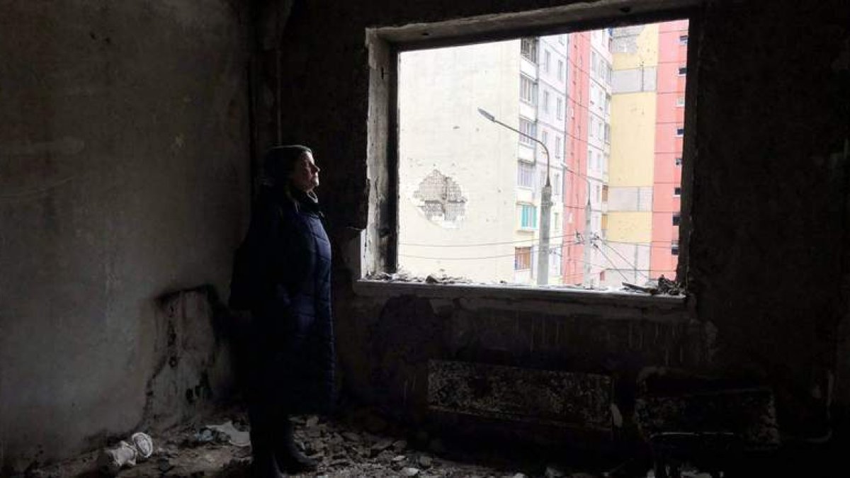 Natalia en su apartamento destruido, puente de Irpin, pintada de Bansky al lado del edificio de Natalia, plaza principal del conjunto de edificios. GERVASIO SÁNCHEZ
