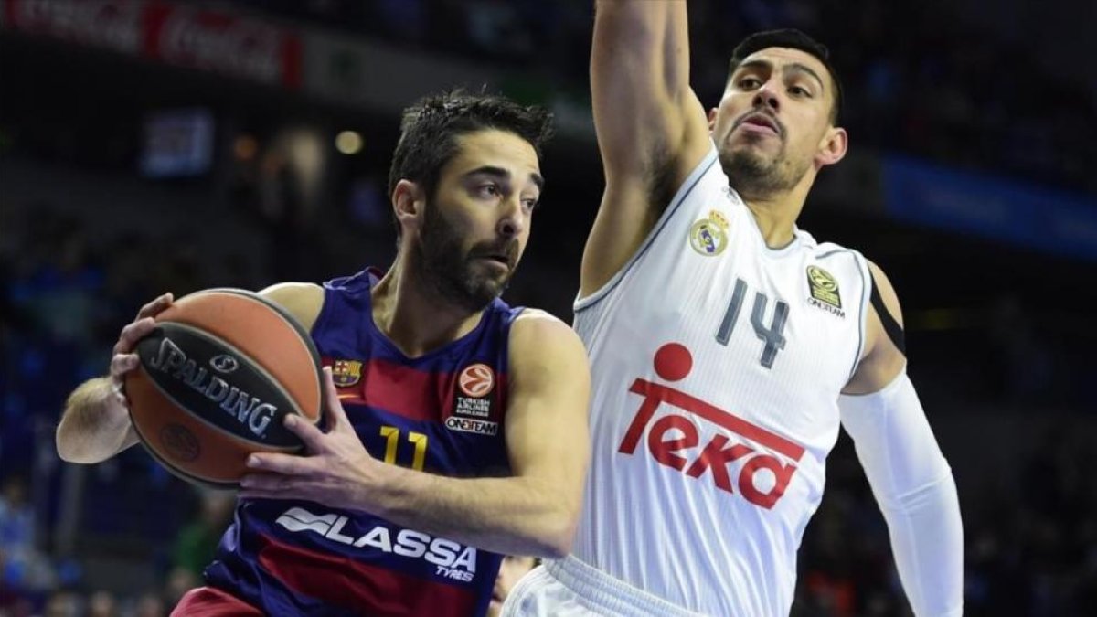 El pívot madridista Ayón intenta frenar una acción de Navarro en un partido de Liga