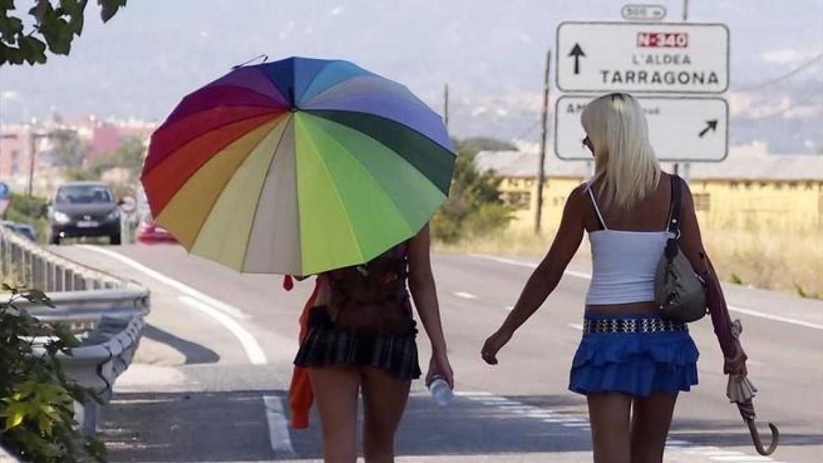 Dos chicas ejercen la prostitución en un carretera.