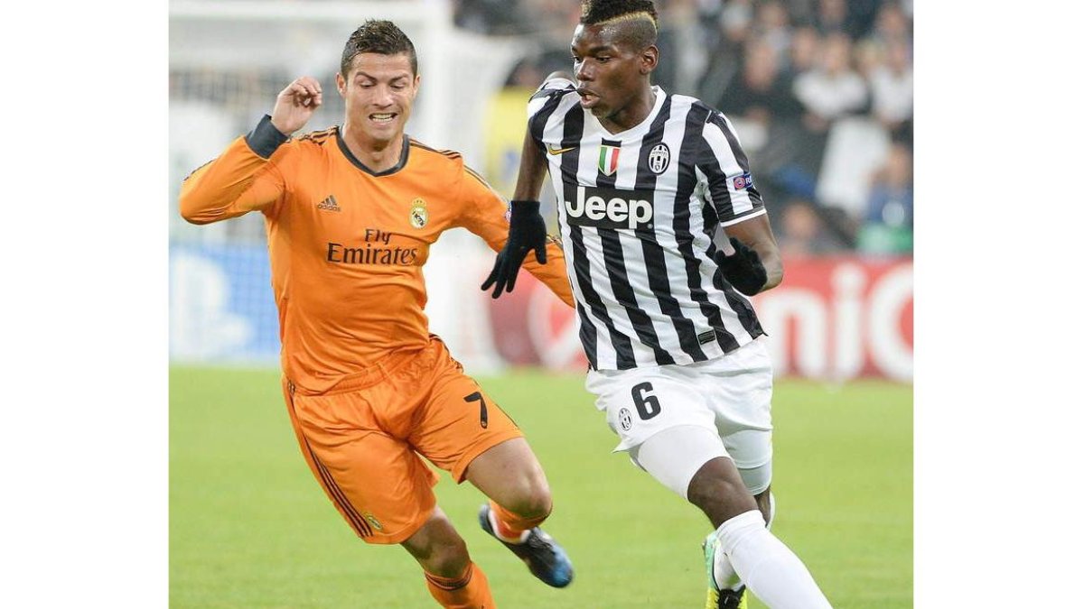 Cristiano Ronaldo pelea por el control del balón con Paul Pogba.