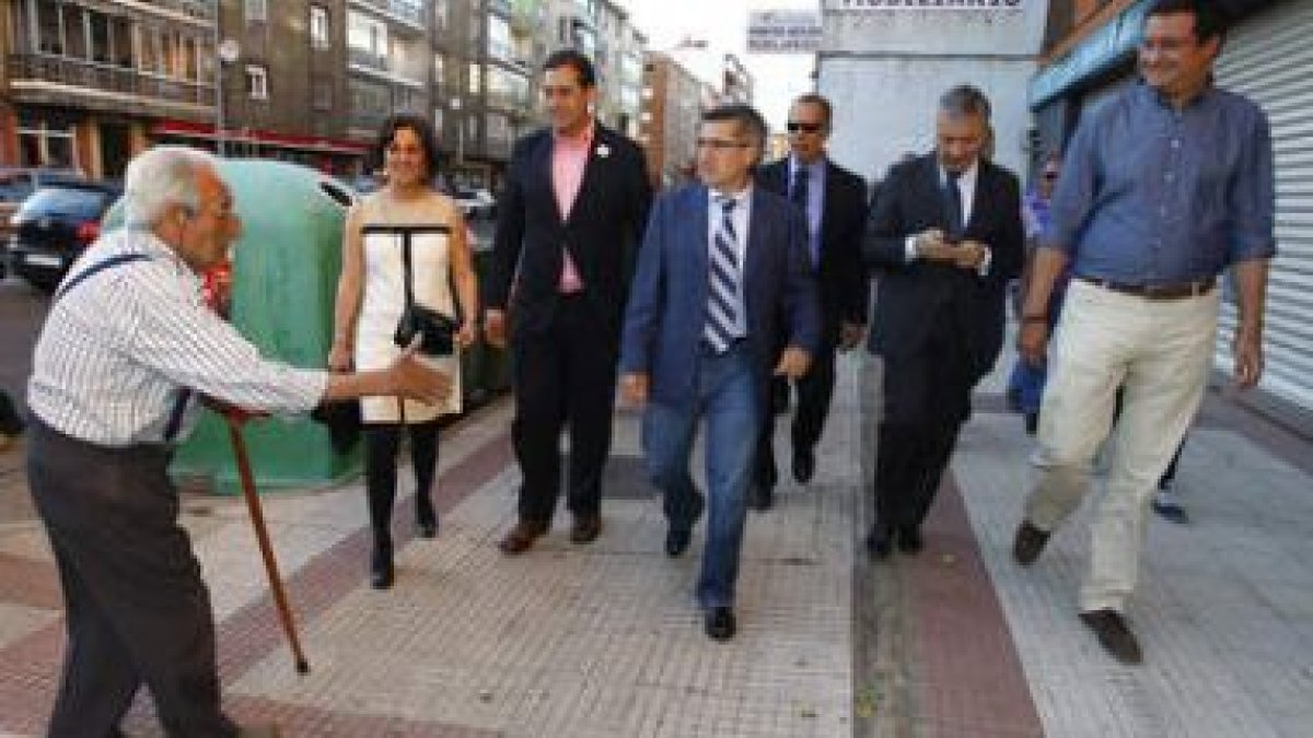 Un hombre tiende el saludo al paso de la comitiva socialista ante María Rodríguez, Fernández Cardo,