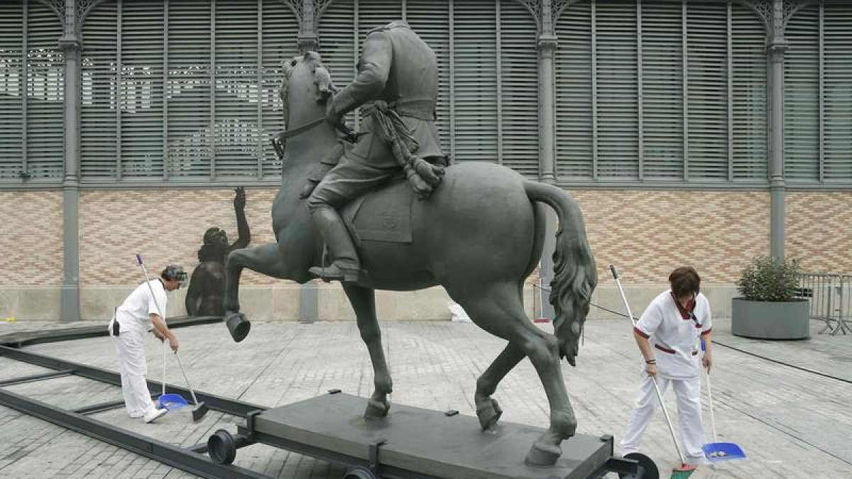 Empleados limpian la escultura ecuestre de Franco. ANDREU DALMAU