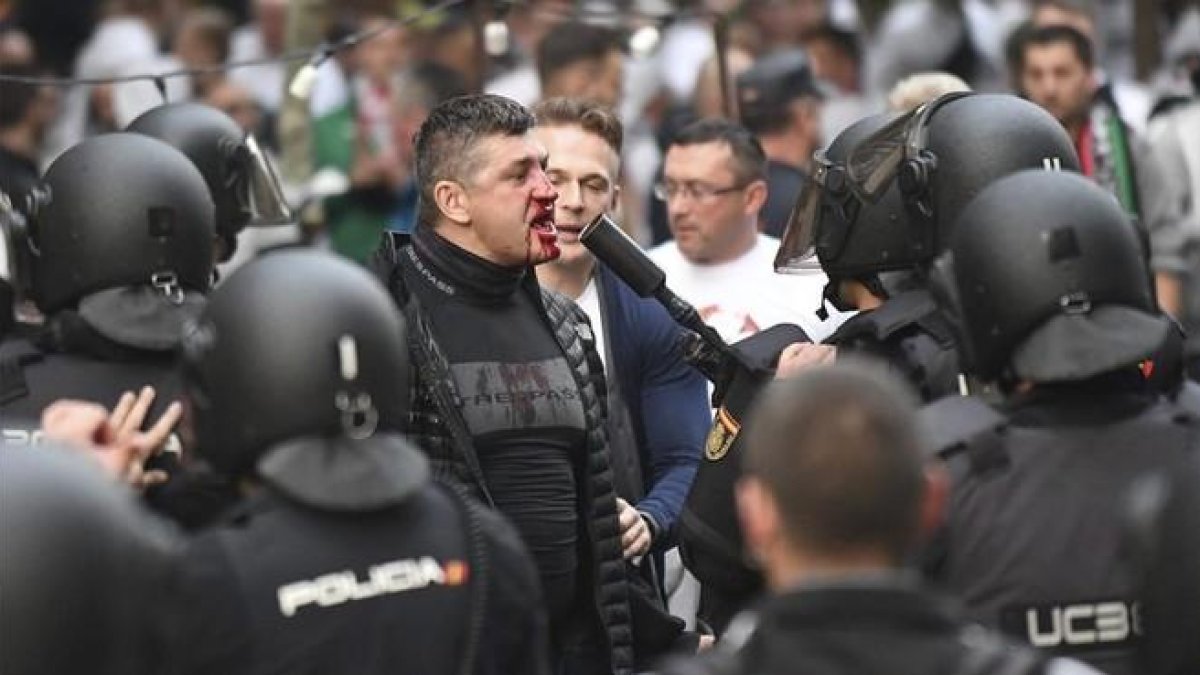 Un hincha polaco con la cara ensangrentada se enfrenta a los antidisturbios, esta tarde junto al Bernabéu.