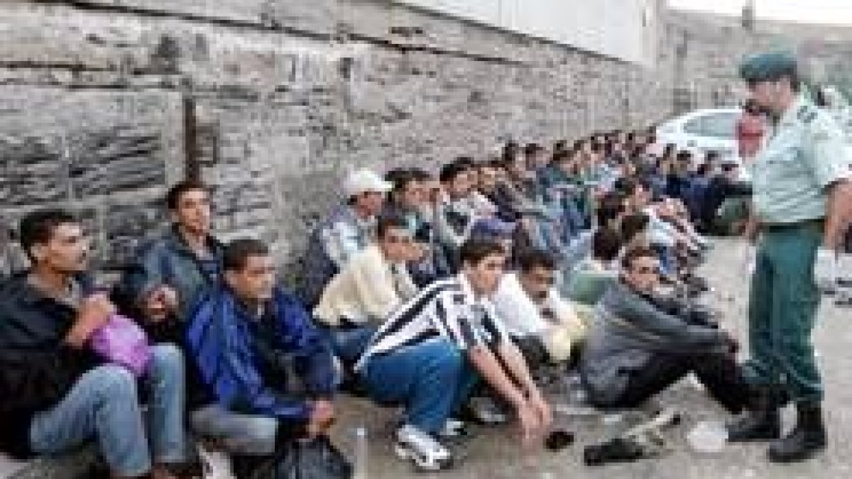 Un policía vigila a un grupo de inmigrantes que llegó ayer a las costas gaditanas
