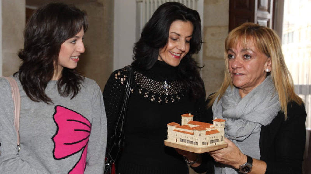 Isabel Carrasco entrega una réplica del Palacio de los Guzmanes a Carolina en presencia de Ruth.