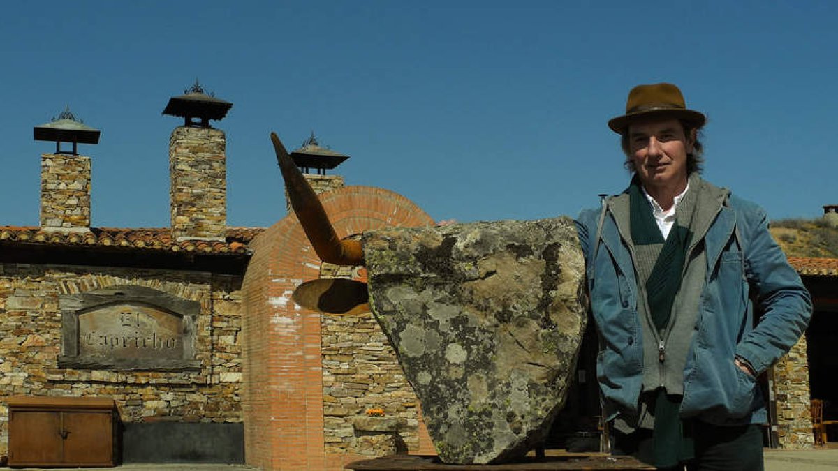 El escultor lacianiego Lolo Zapico, junto a la pieza que ahora preside la entrada al famoso restaurante leonés.