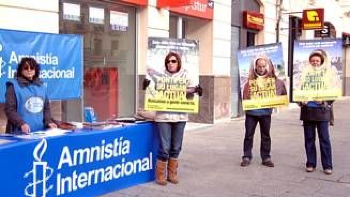 Un grupo de activistas de Amnistía Internacional posan con los carteles de denuncia