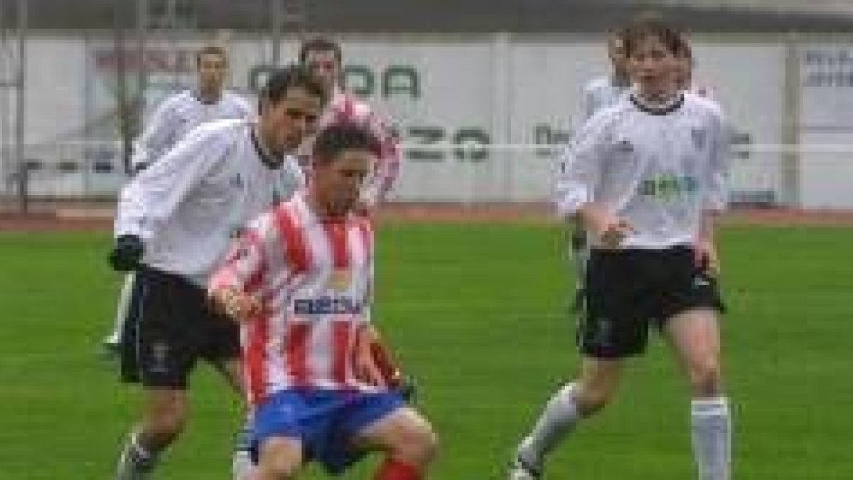 Óscar García pugna con un rival por hacerse con la posesión del balón