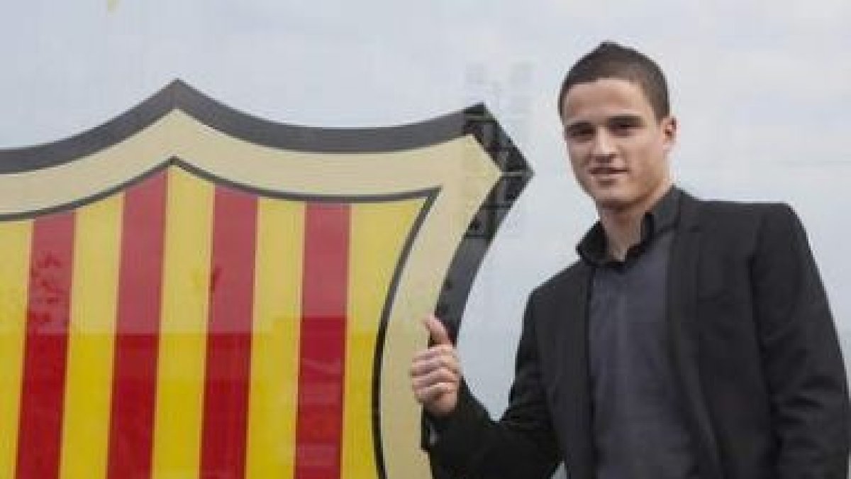 Afellay posa ante el escudo del club azulgrana.