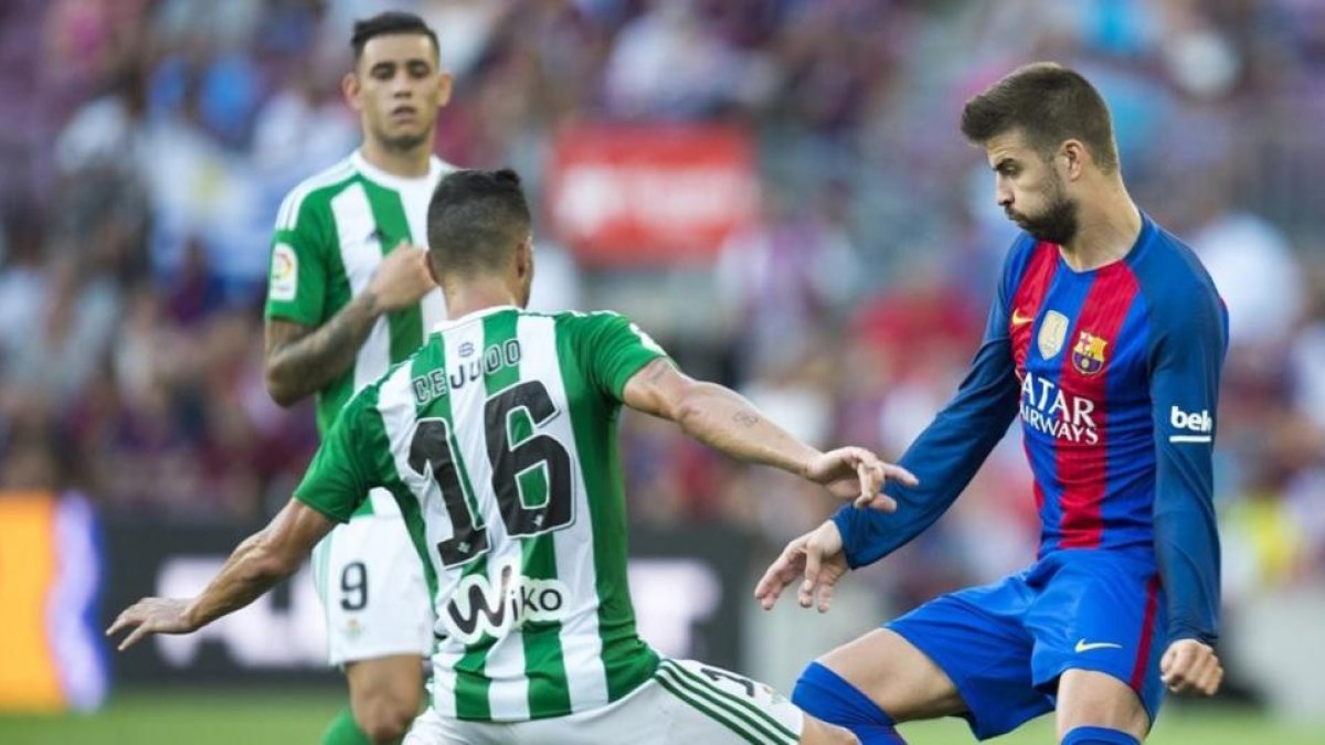 Piqué, junto a Cejudo, en el Barça-Betis de la primera jornada.