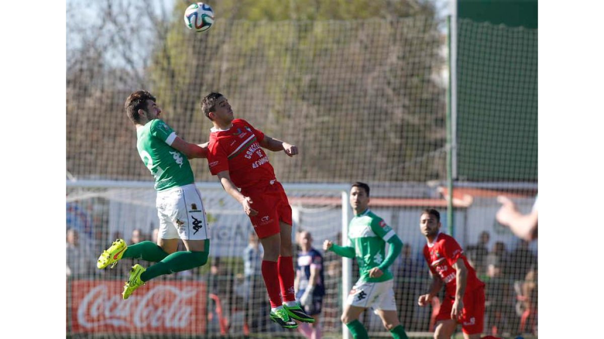 Cristian despeja un balón ante la oposición de Héber