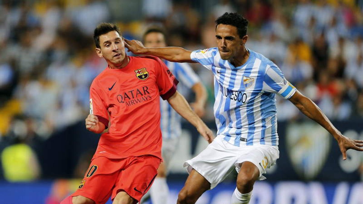 Messi intenta regatear al malaguista Welington. El argentino no acertó ante la portería rival.