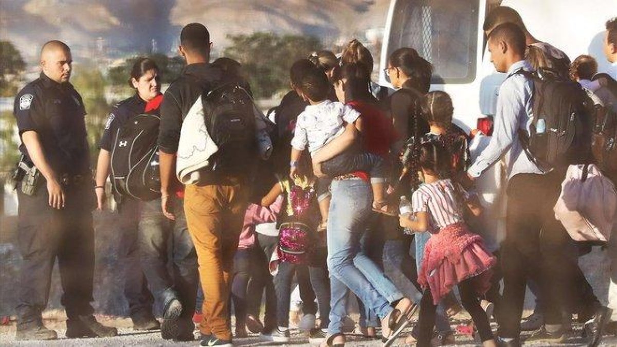 Policías estadounidenses custodian a un grupo de inmigrantes que han sido detenidos por entrar ilegalmente en EEUU.