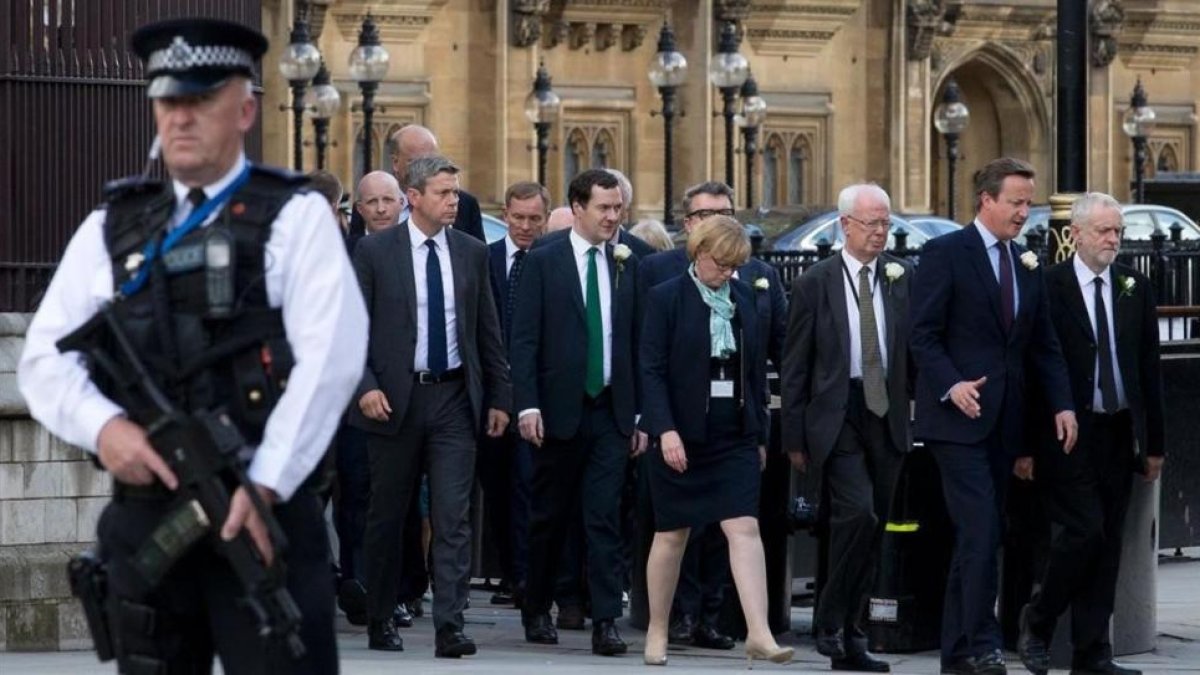 El primer ministro británico David Cameron (segundo por la derecha) camina junto al líder del partido laborista Jeremy Corbyn (derecha) mientras abandonan el Parlamento tras la sesión para honorar a la diputada asesinada Jo Cox.