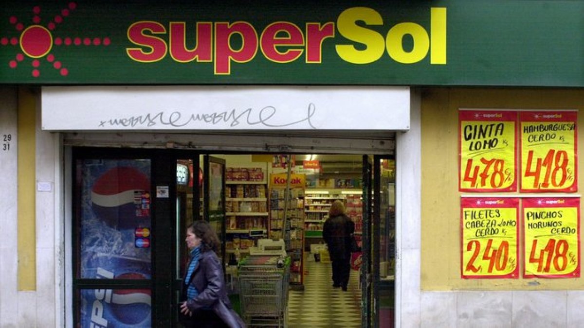 Una cliente sale de un supermercado SuperSol, en una centrica calle de Sevilla.