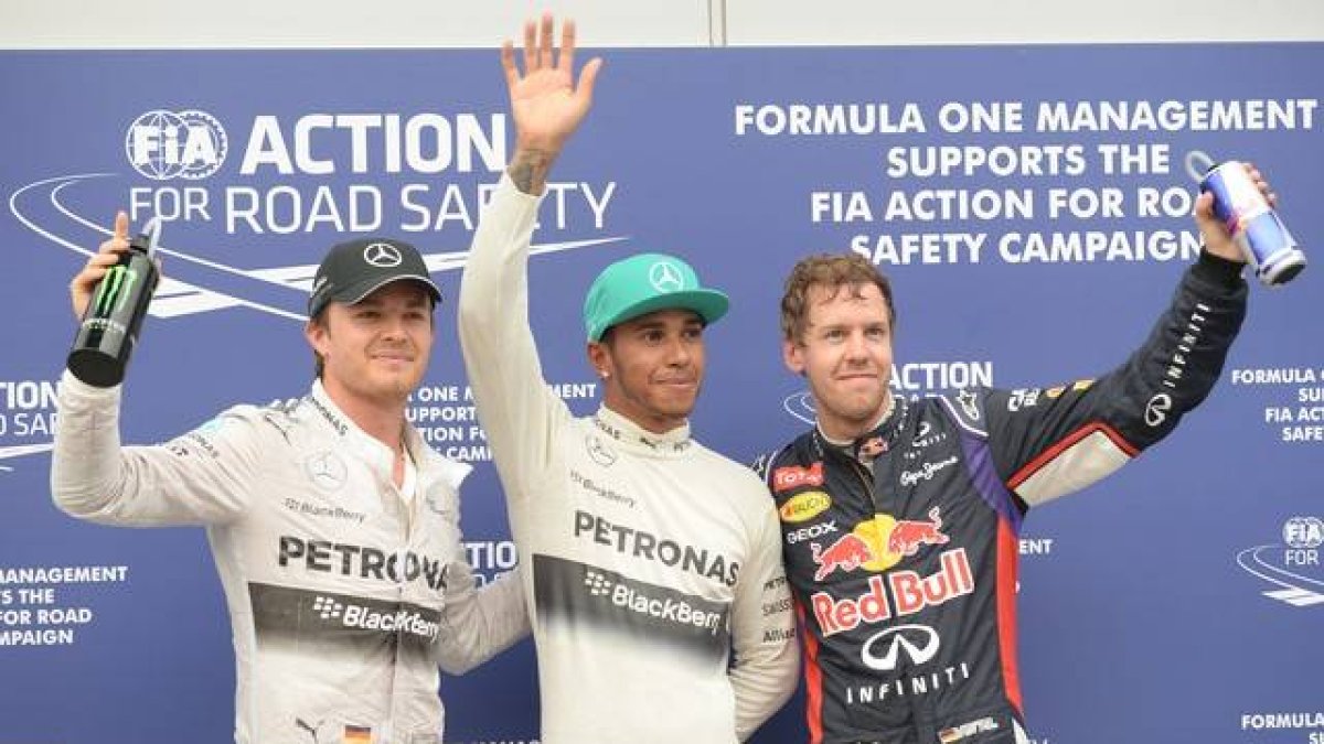 El piloto de Mercedes Lewis Hamilton, el piloto de Red Bull Sebastian Vettel y el de Mercedes Nico Rosberg de Alemania después de que Hamilton haya conseguido la 'pole' en el Gran Premio de Malasia.