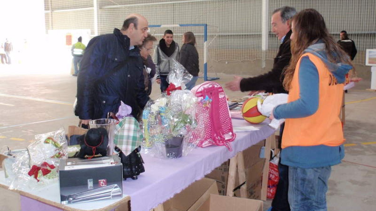 Algunas personas miran los objetos del mercadillo de trueque de la feria solidaria.