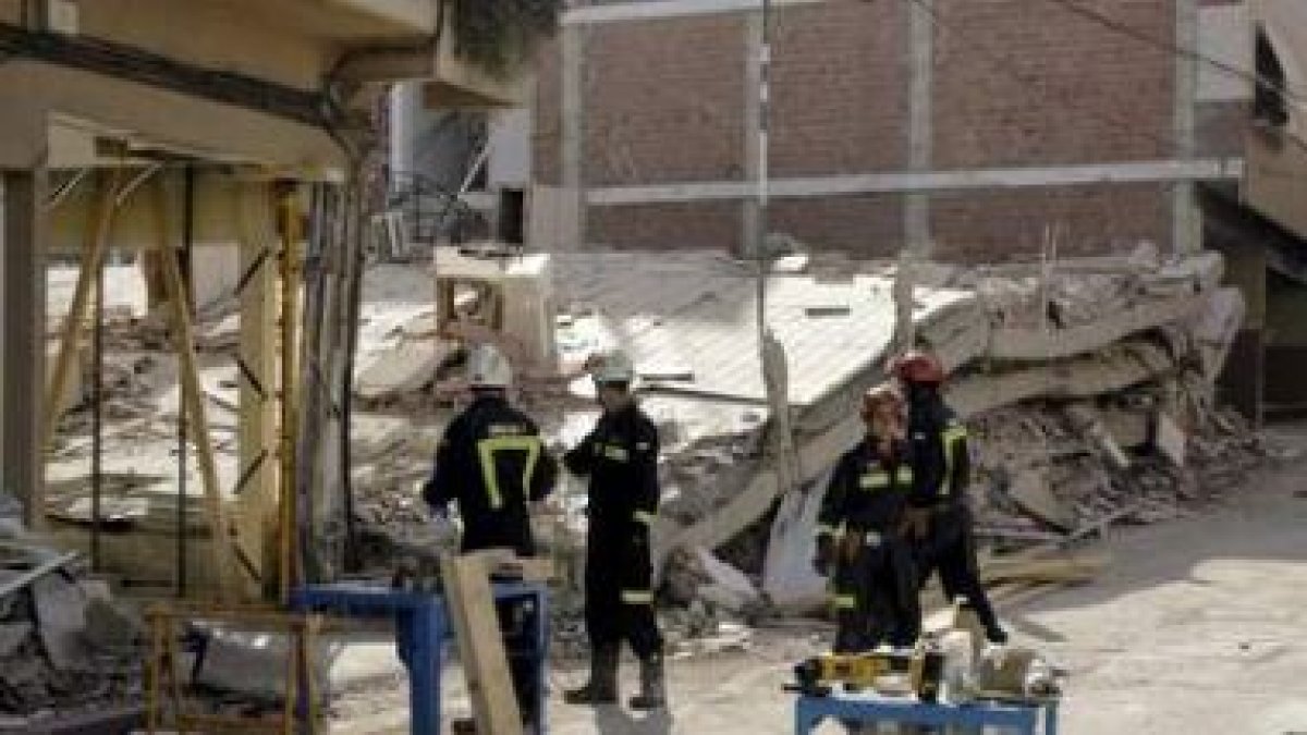 Varios bomberos apuntalan un edificio del barrio de La Viña de Lorca.