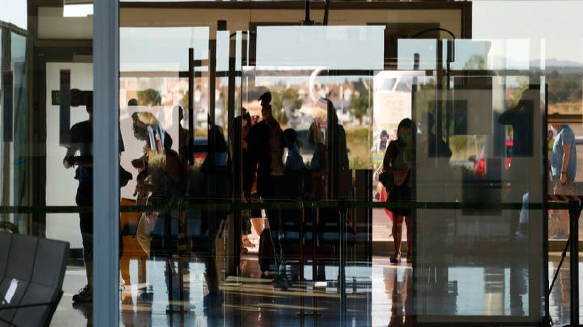 Pasajeros pasan el arco de seguridad en el aeropuerto de León. FERNANDO OTERO