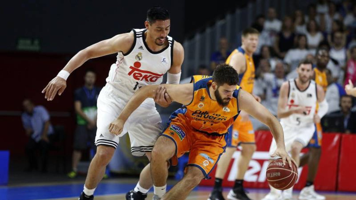 El alero del Real Madrid Gustavo Ayón (i) presiona al pívot del Valencia Basket Bojan Dubljevic (d), durante el partido de playoff de semifinales de la Liga Endesa que han disputado hoy en el Barclaycard Center de Madrid.