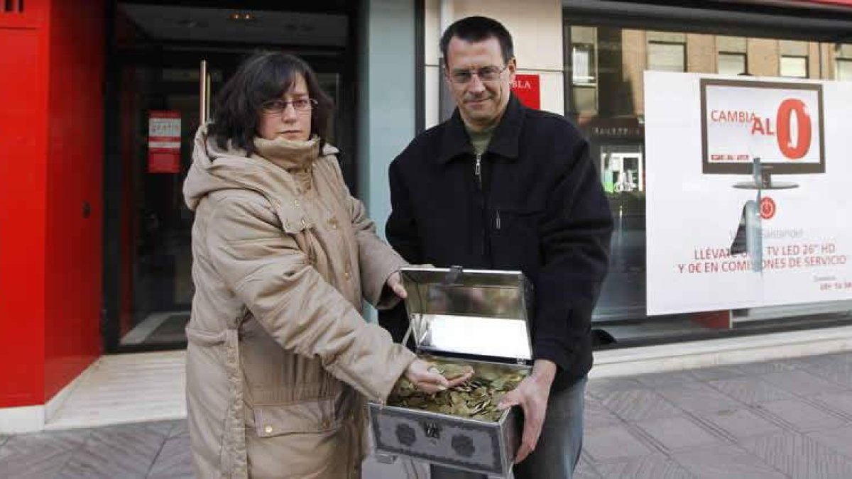 Nohelia y Florencio muestran las monedas antes de entregarlas en la oficina.