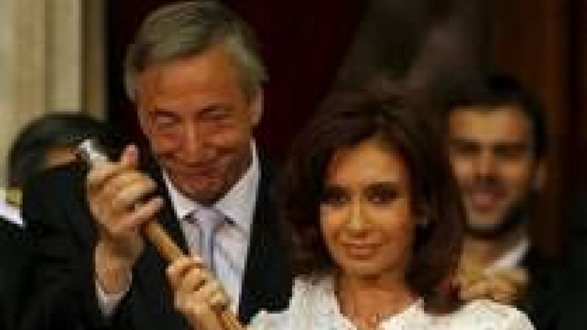 El presidente saliente y esposo con gesto de satisfacción tras la ceremonia de toma de poder