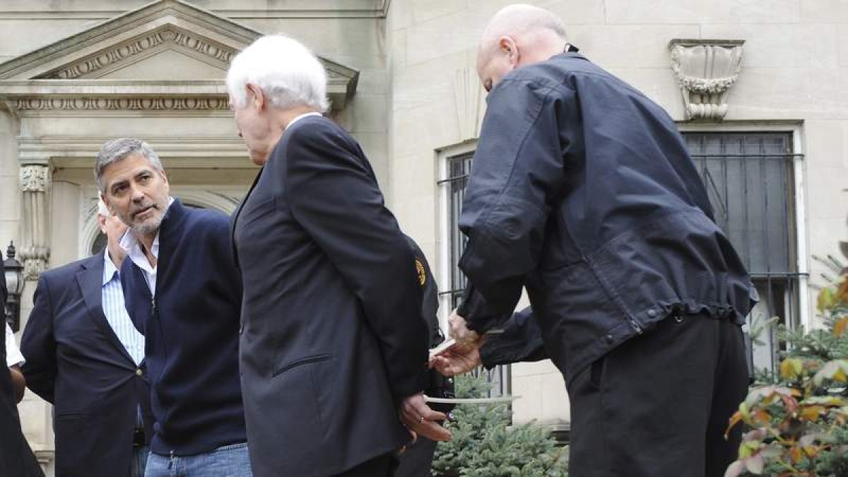 El actor George Clooney y su padre, Nick Clooney, en el momento de ser esposados por la policía.
