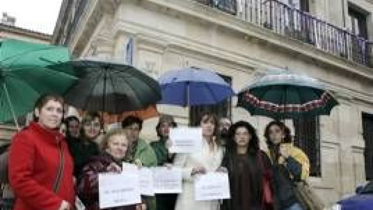 Representantes de la Plataforma contra la Violencia Machista de León bajo los lazos morados