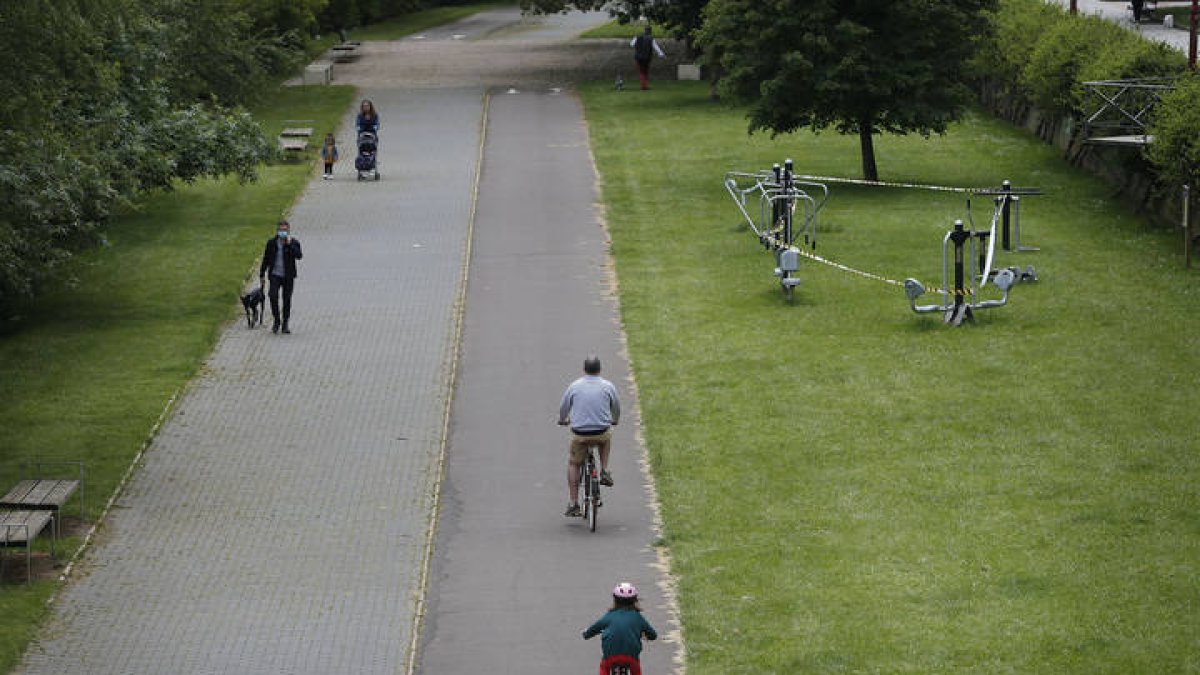 Varias personas pasean andando y en bici junto al Bernesga. JESÚS F. SALVADORES