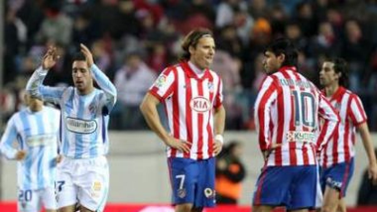 Diego Forlán y el Kun Agüero se desesperan tras el segundo gol del Málaga.