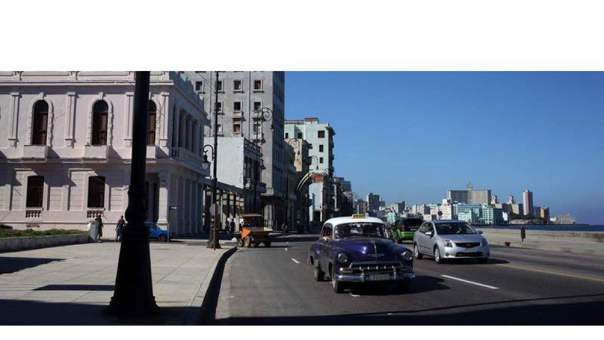 Malecón de La Habana, una de las estampas más típicas de Cuba, en una imagen reciente con un típico viejo auto transitando camino de la ciudad.